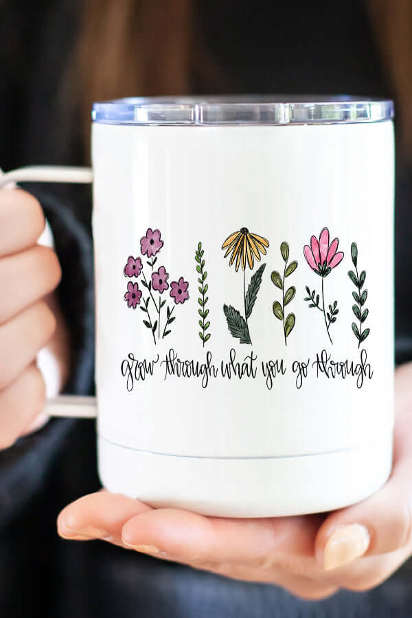 Grow Through Travel Cup with floral design and motivational text, perfect for enjoying warm beverages on the go.