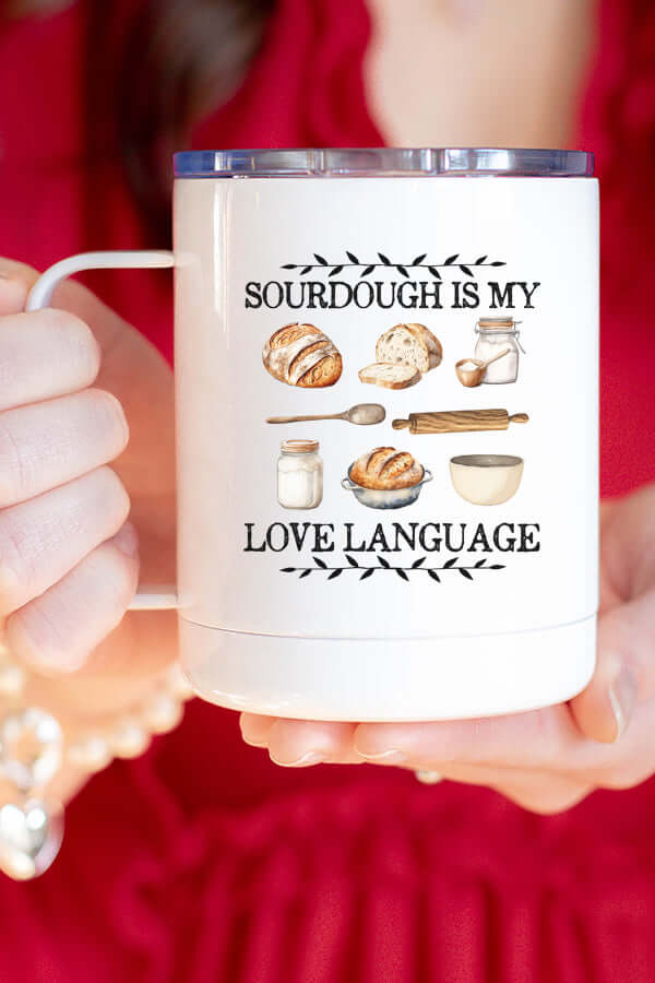 Woman holding a stainless steel coffee cup with the phrase 'Sourdough is my Love Language' and bread illustrations.