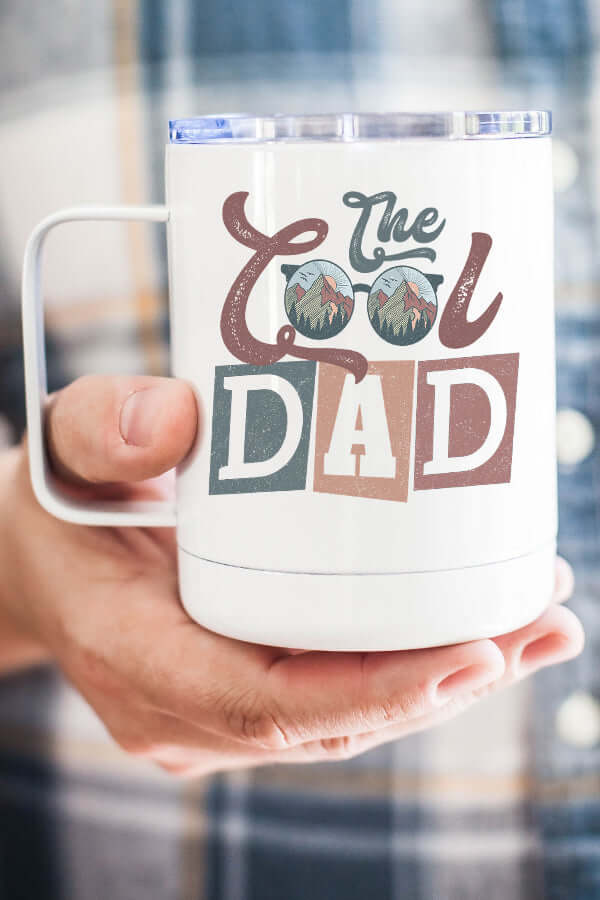 Cool Dad Coffee Cup with stylish design held by a person, perfect for sipping beverages on the go.