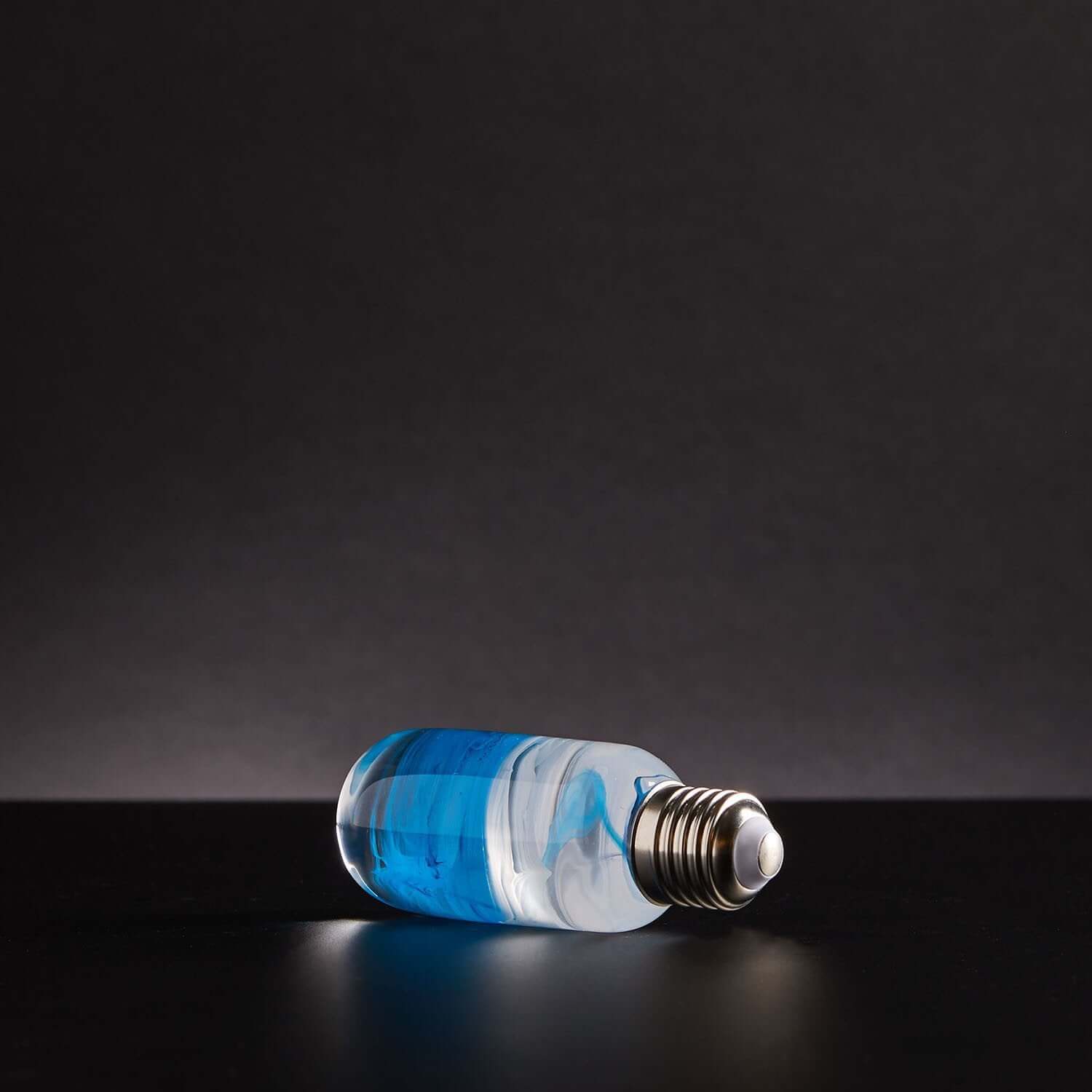 Elegant Blue Lamp on a dark background, showcasing its sleek design and vibrant blue finish.