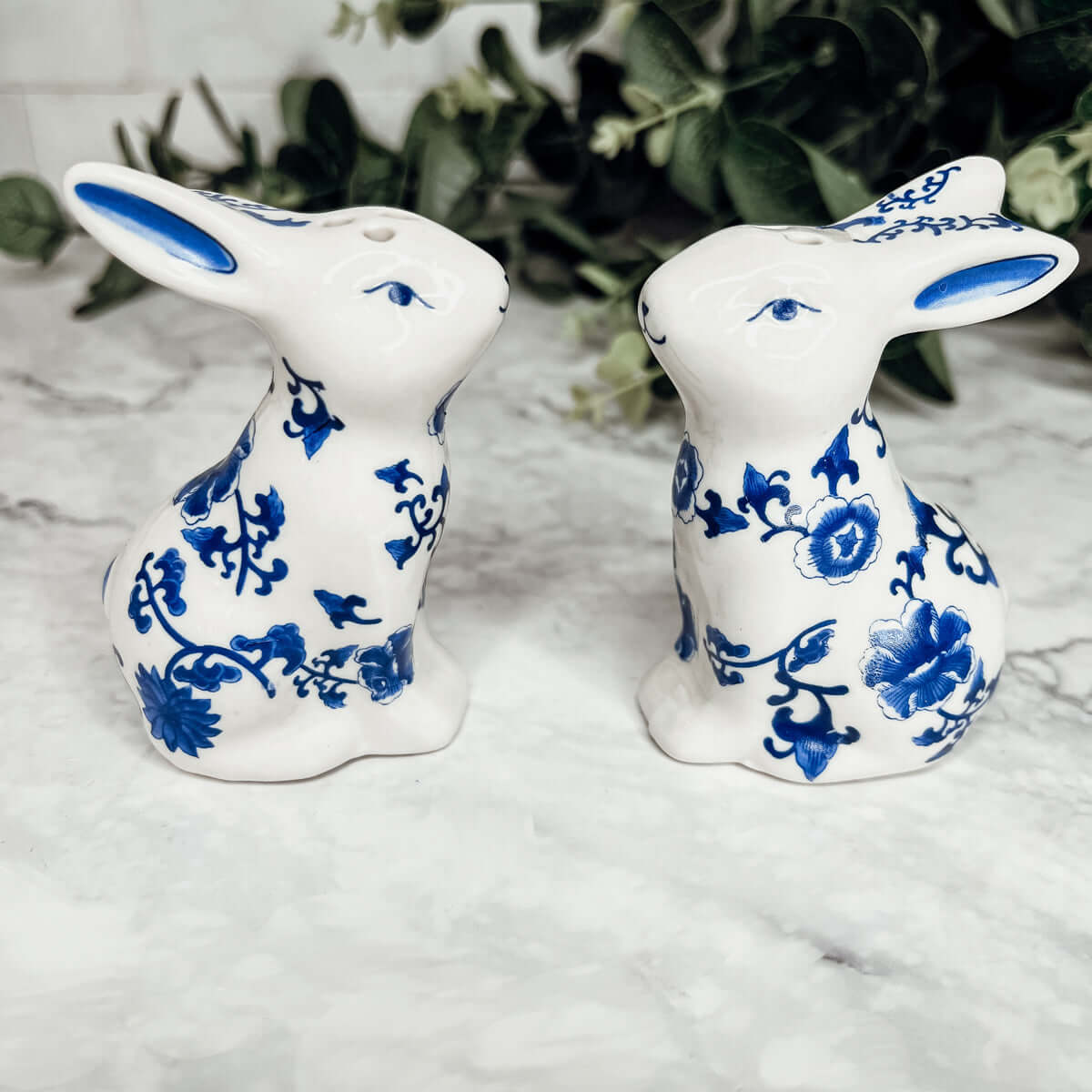 Blue Bunny Shakers, decorative ceramic salt and pepper shakers shaped like bunnies, featuring blue floral designs.