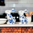 Blue Bunny Shakers ceramic figurines in blue floral design on kitchen counter with cooking utensils.