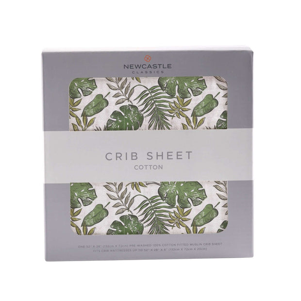 Tropical crib sheet with green leaf pattern in a box, made from soft cotton for comfortable baby bedding.