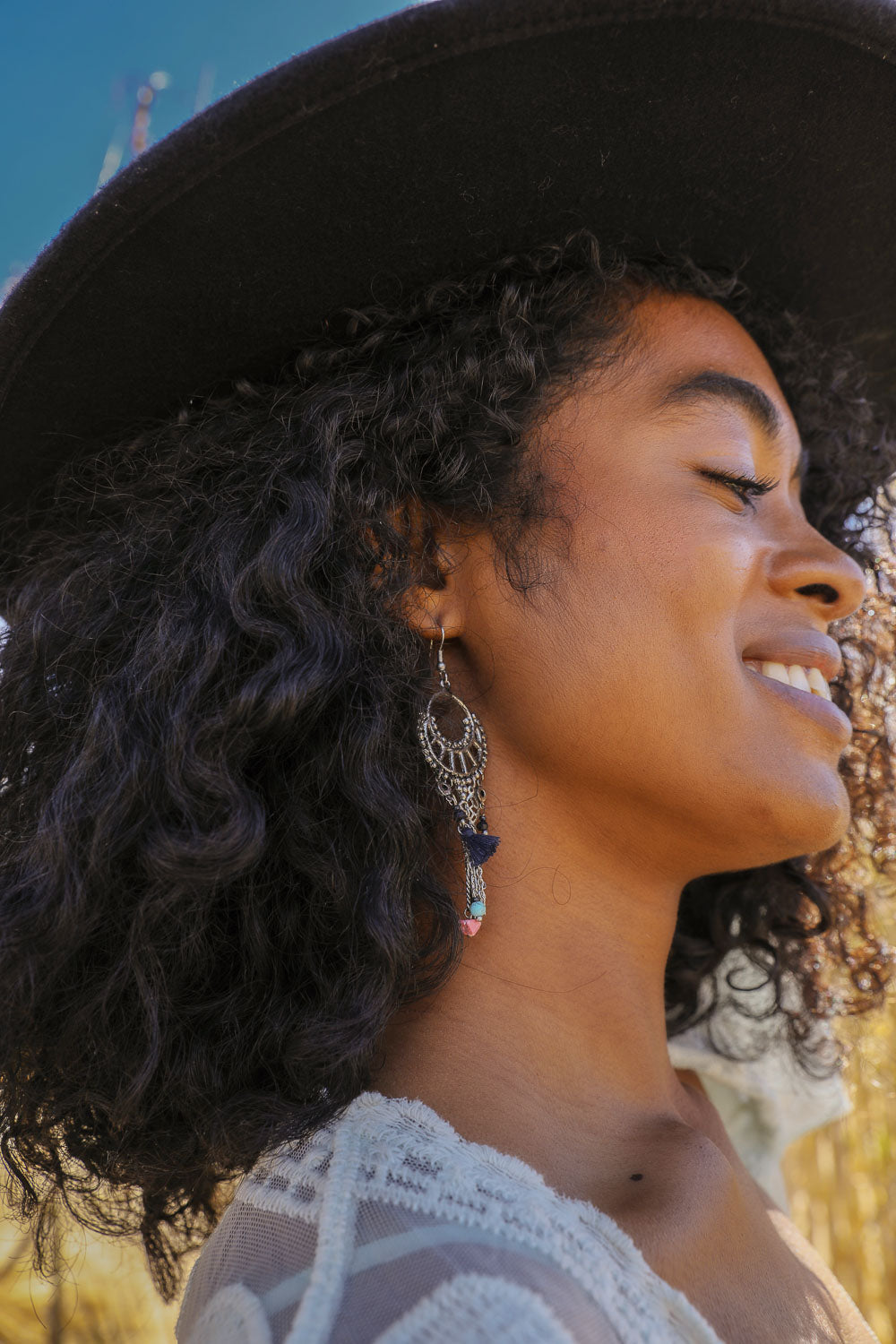Boucles d'oreilles pendantes en quartz rose et pompons.