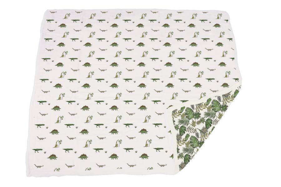 Dino Days Newcastle Blanket featuring playful dinosaur prints and a leafy pattern on the reverse side.