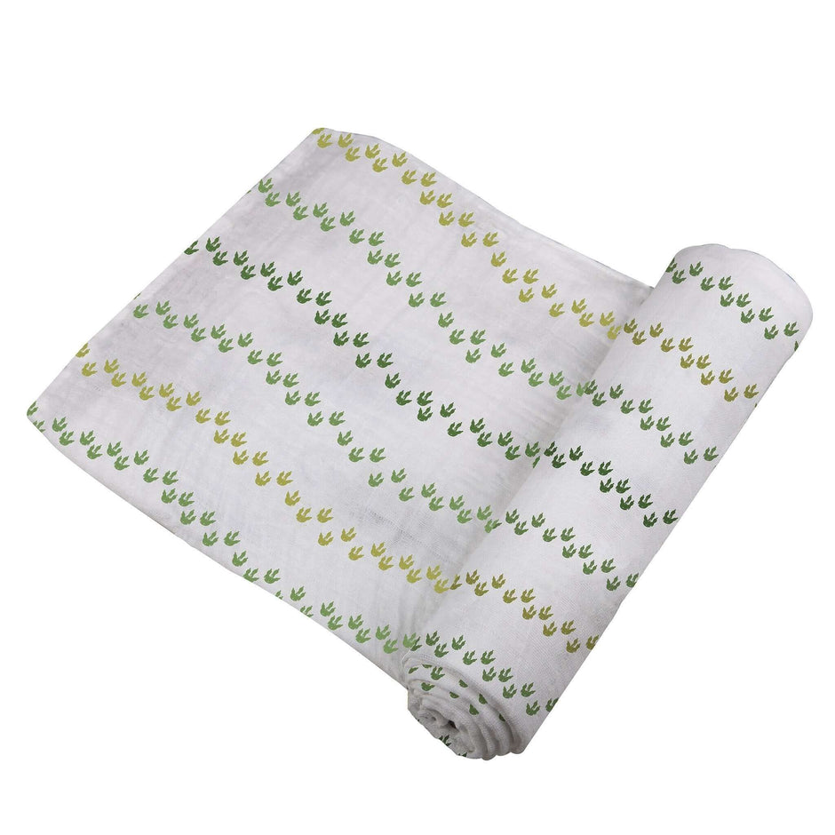 Dino Feet Cotton Muslin Swaddle featuring green and yellow dinosaur footprints on soft cotton fabric.