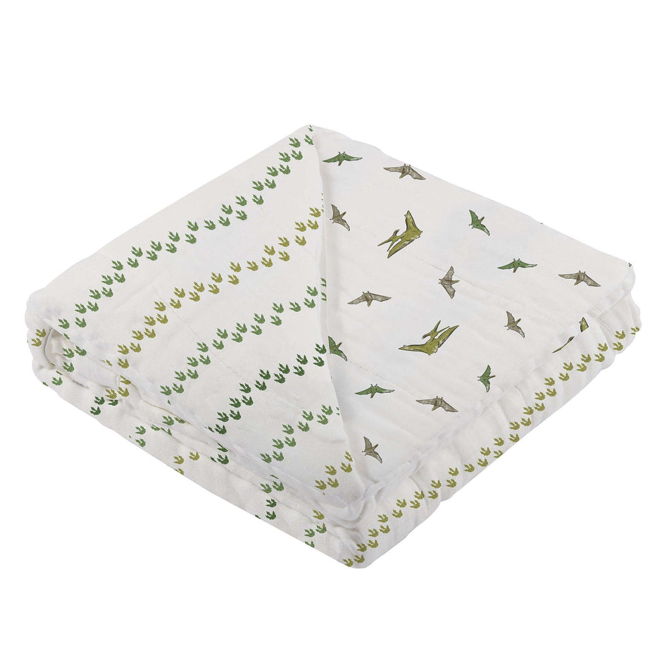 Dino Feet Muslin Blanket featuring playful dinosaur footprints and illustrations, perfect for cozying up.